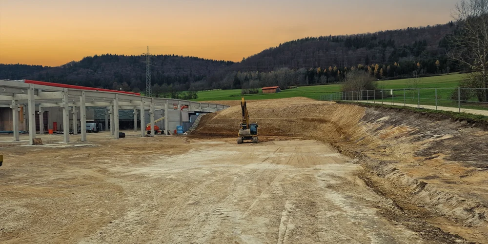 Bauvermessung auf einer Baustelle mit Bagger